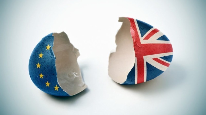 A cracked egg shell one half with EU flag and the other half with UK flag