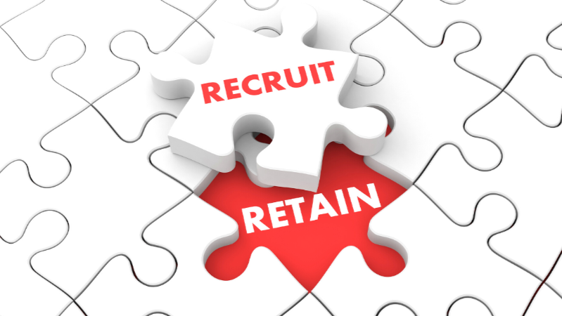 White jigsaw puzzle wtih the words "recruit" and "retain" written on them