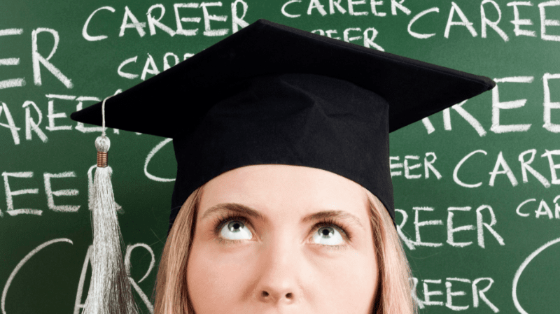 Graduate wearing cap in front of green chalk board with "career" written multiple times behind them